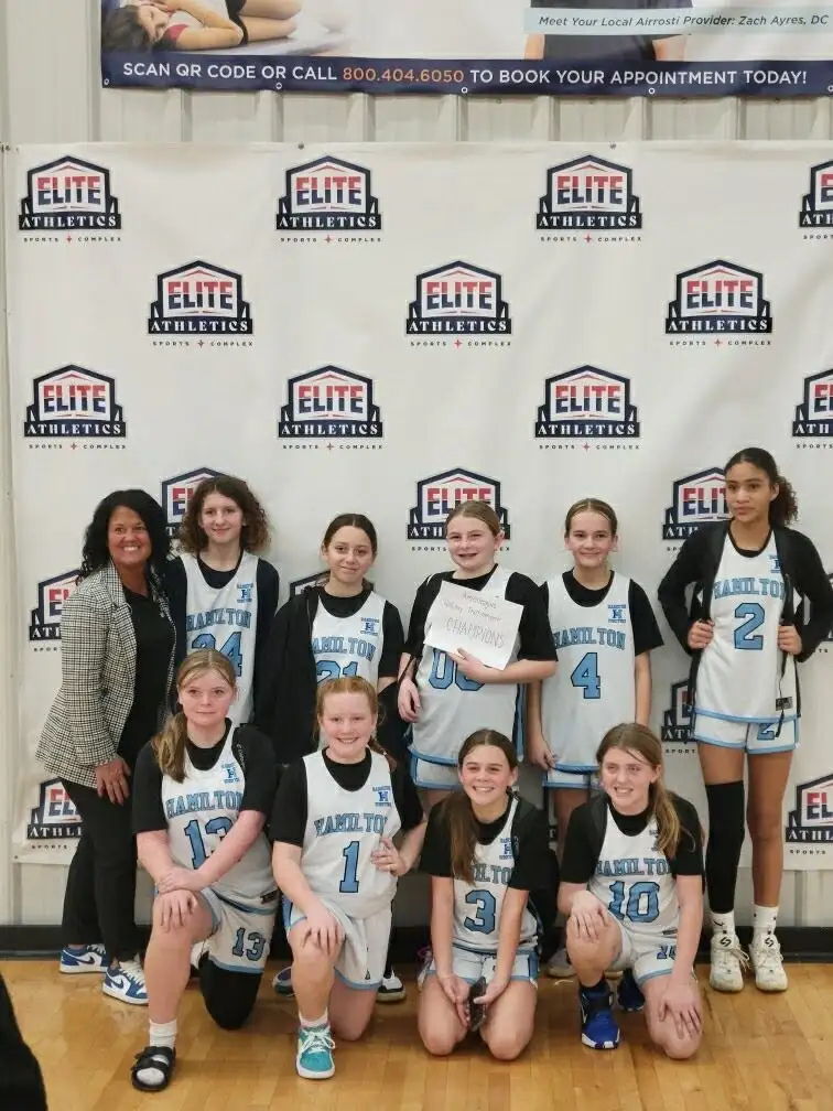 Hamilton United's 6th grade team in club jerseys, holding a championship sign